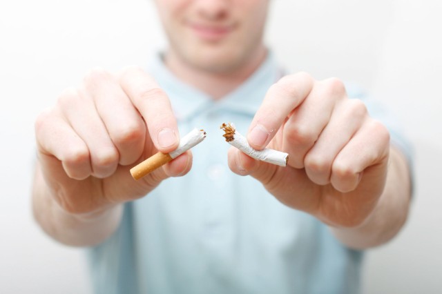 man ripping cigarette in half